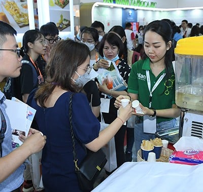 exhibitor handing out tasters at Fi Vietnam