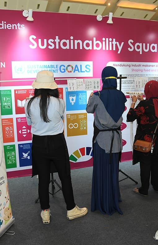 Visitors looking at signage at sustainability square at Fi Asia Indonesia