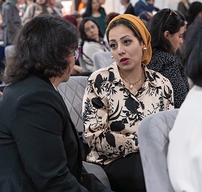 Two attendees chatting while attending the conference.