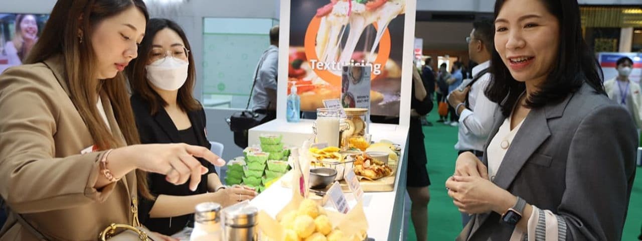 Visitor smiling at exhibitor stand