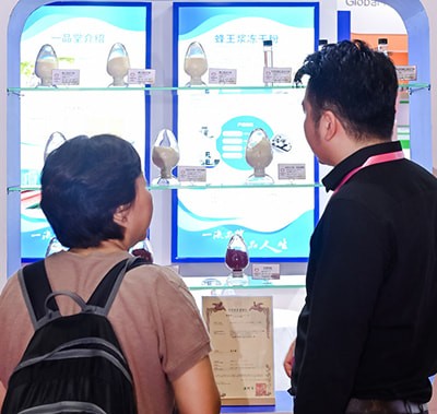 Attendee and exhibitor chatting in front of the booth