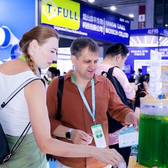 Attendee and exhibitor chatting in front of the booth