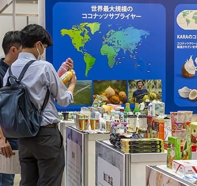 visitors inspecting products at exhibitor booth at Hi Japan