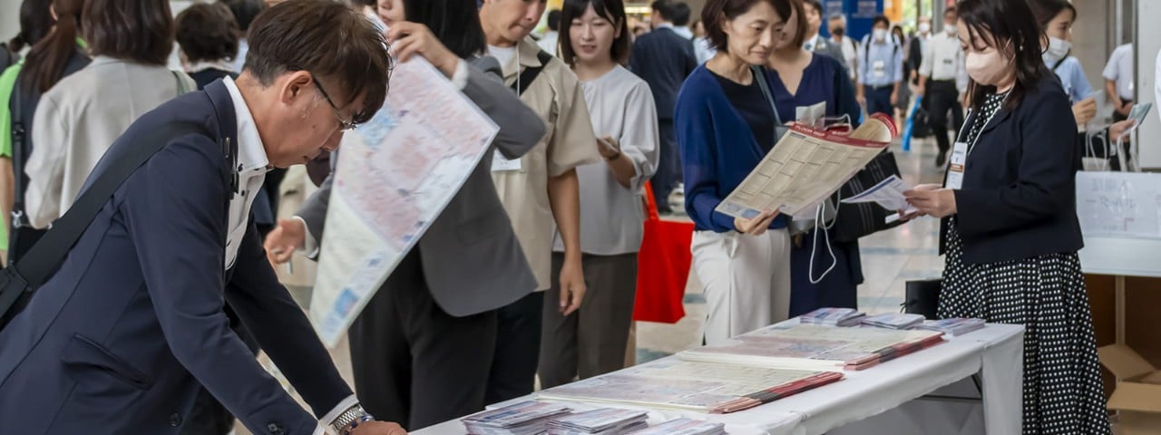Visitors looking at product information leaflets at Hi Japan