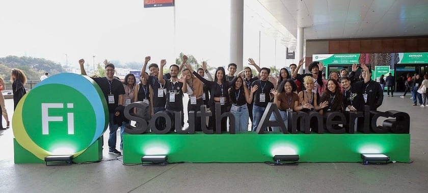 visitors posing in front of sign at Fi South America