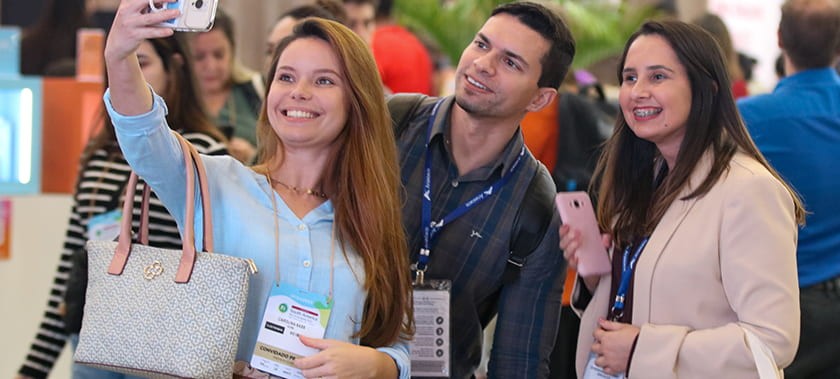 Event attendees smiling and taking a selfie at Fi South America