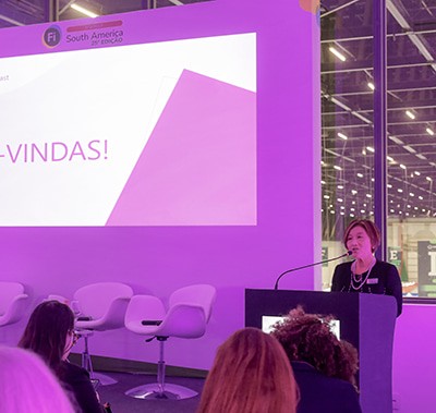 Speaker at podium during the women's networking breakfast at Fi South America