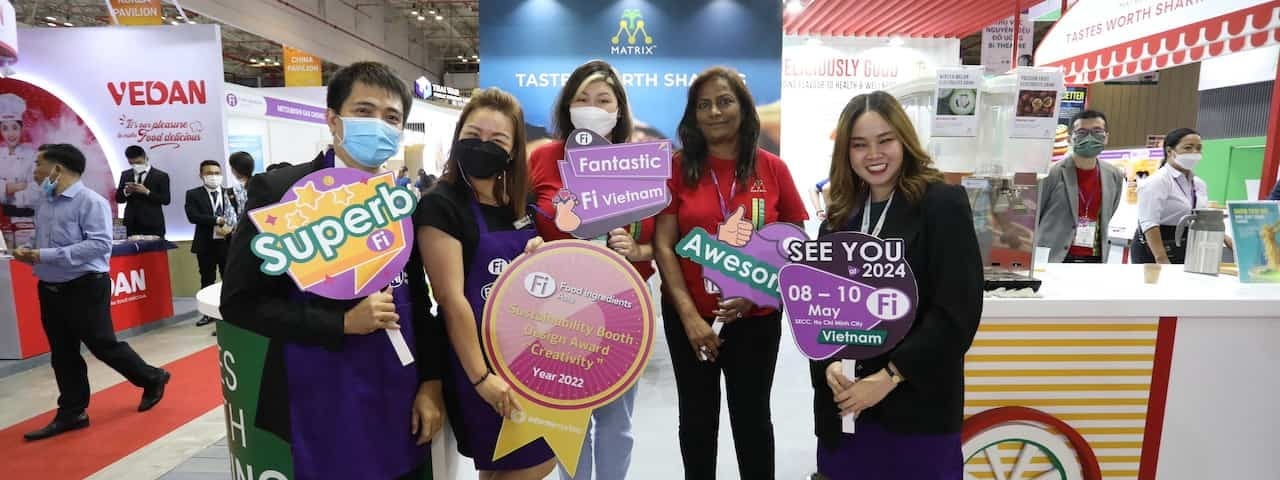 Visitors posing with signs at Fi Vietnam