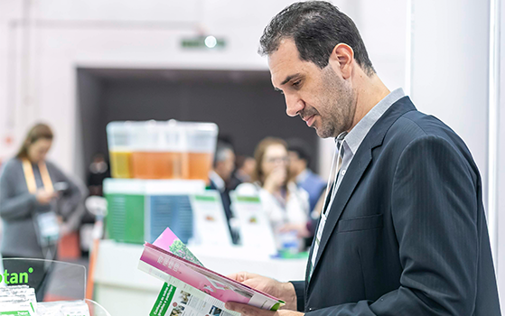 Visitor reading event brochure at Fi South America
